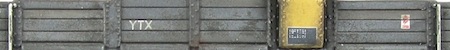 A brake van showing the paint peeling leaving the exposed wood underneath.